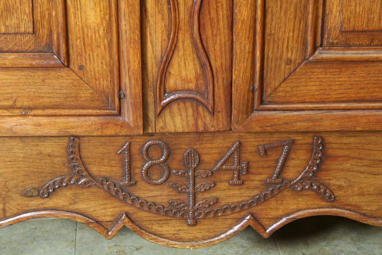 Hand carved oak Louis XV style Normandy armoire from Le Perche region of France.  This armoire was a wedding gift commissioned by a father for his daughter, and the hand carved year of 1847 in lower apron commemorates the year of the marriage.
