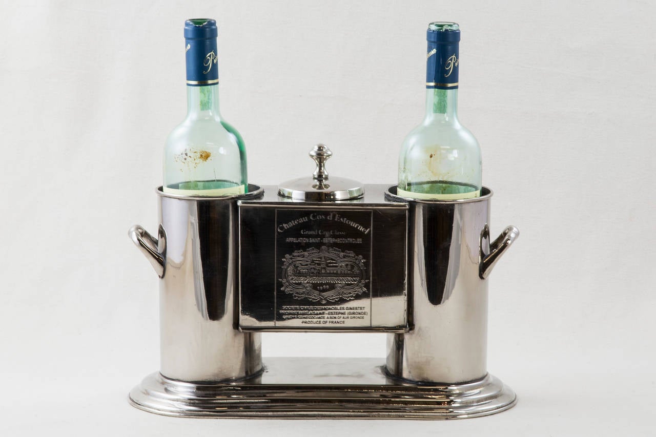 This stunning mid-20th century silver plate wine chiller holds two bottles and has a central compartment with lid for ice. With silver handles at each side for carrying, this piece will bring an elegant touch to any dining or bar space. Each side