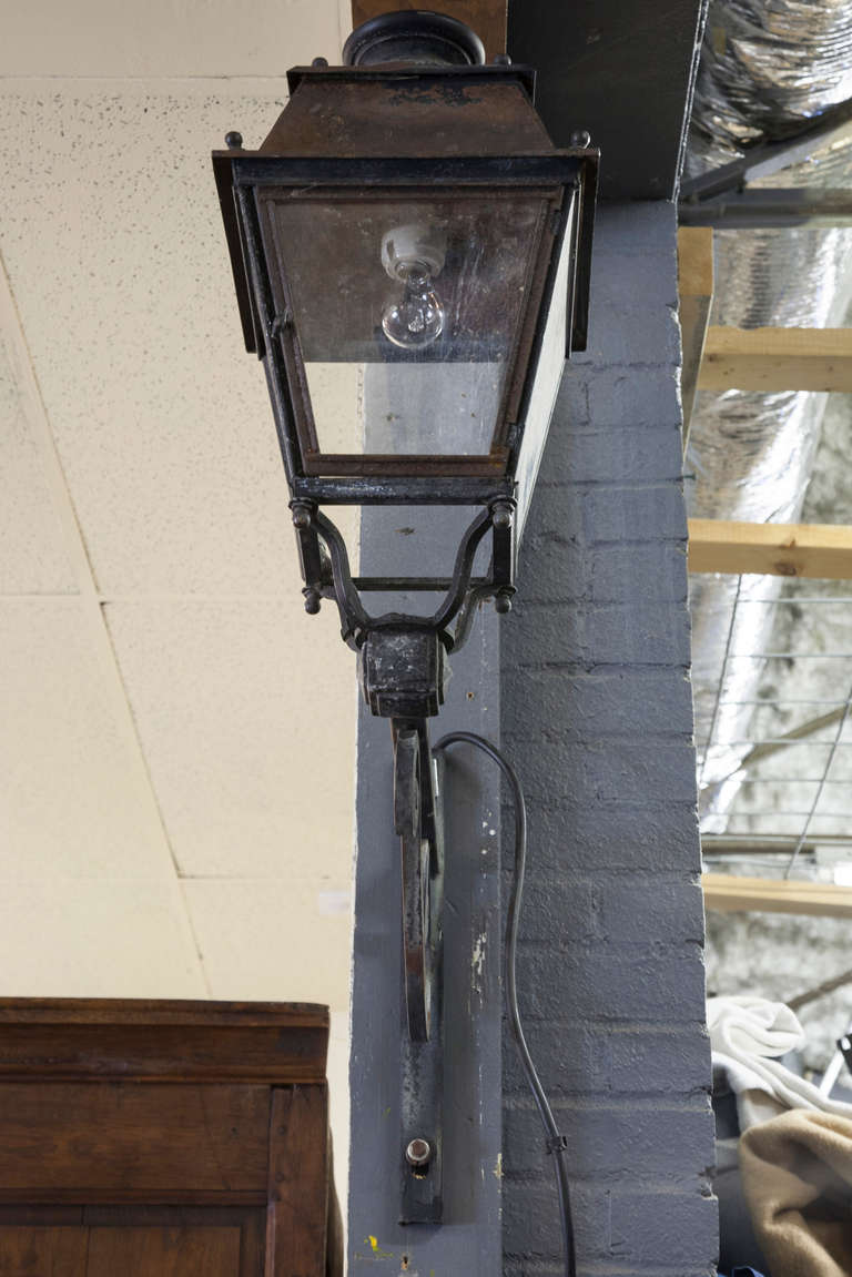 This 1900s large iron lantern is mounted on its iron bracket.  It was originally plumbed for gas and hung outside as a street light in France.  It has recently been converted to electricity.