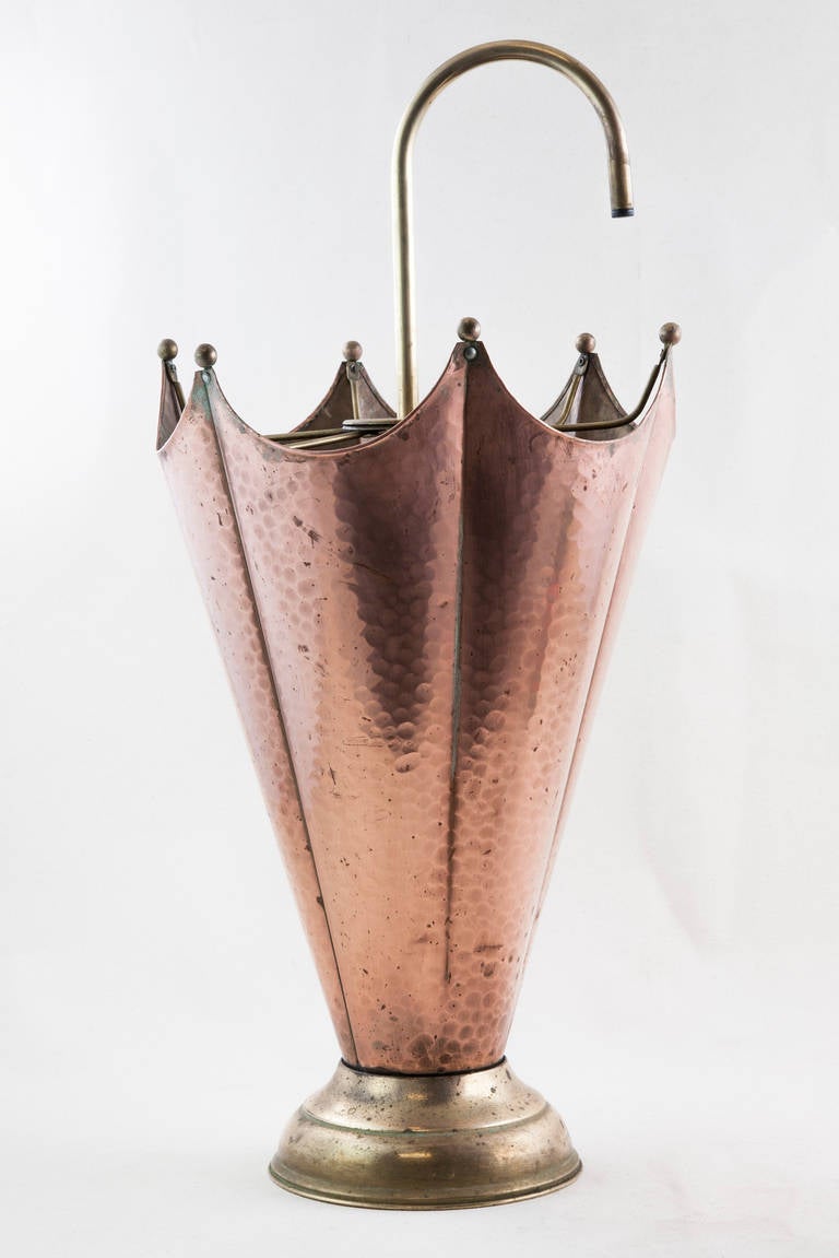 This midcentury umbrella stand of hand hammered copper takes the form of an  open umbrella resting on a brass base.  Found in Normandy, France,  this piece will add charm as well as function to your entryway. Base measures 7