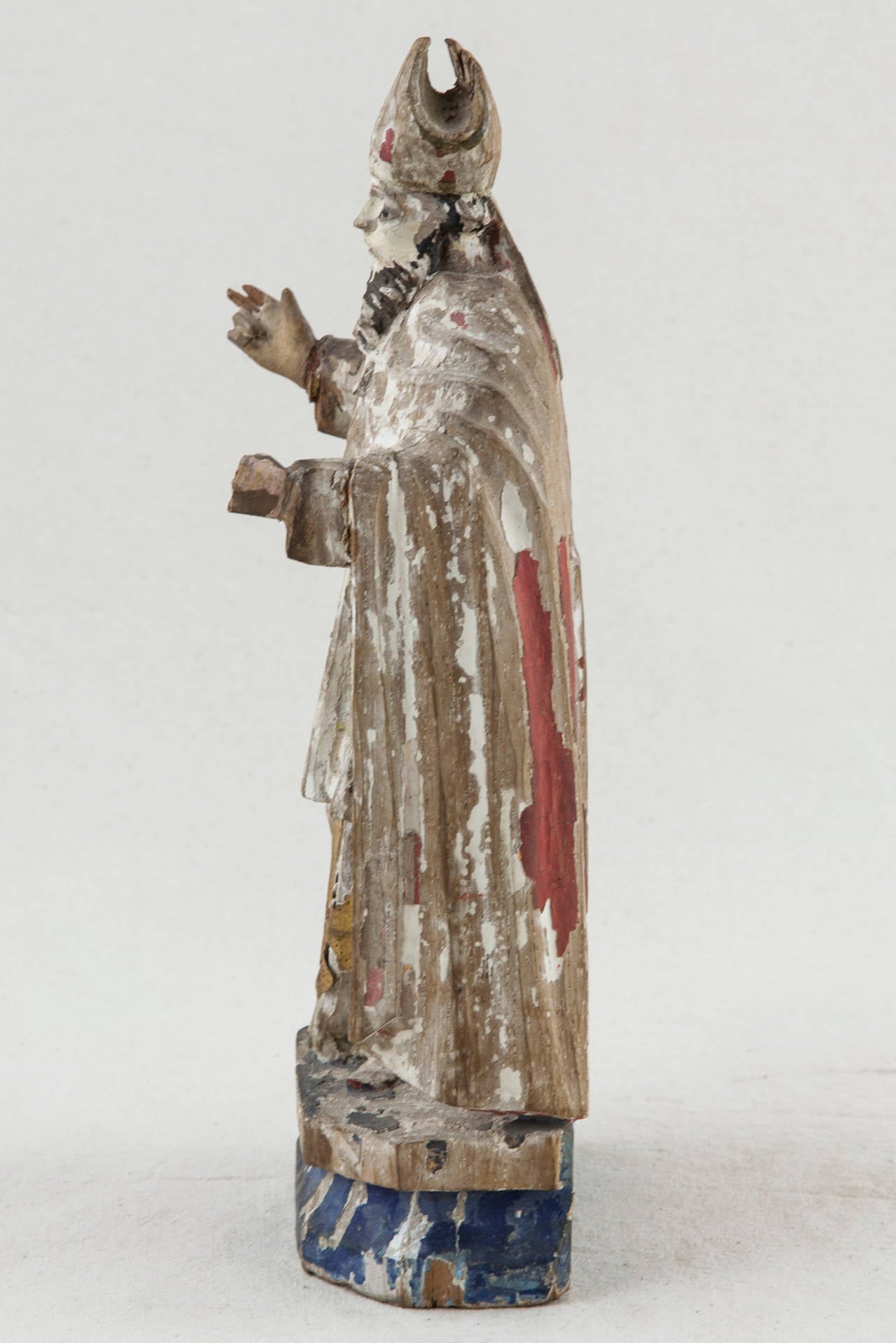 Created in the mid-1600s in France, this rare figure of a bishop with outstretched arms was originally finished in polychrome colors of ruby red and azure blue with gilt detail. In its beautifully aged state that only four centuries can bring and at