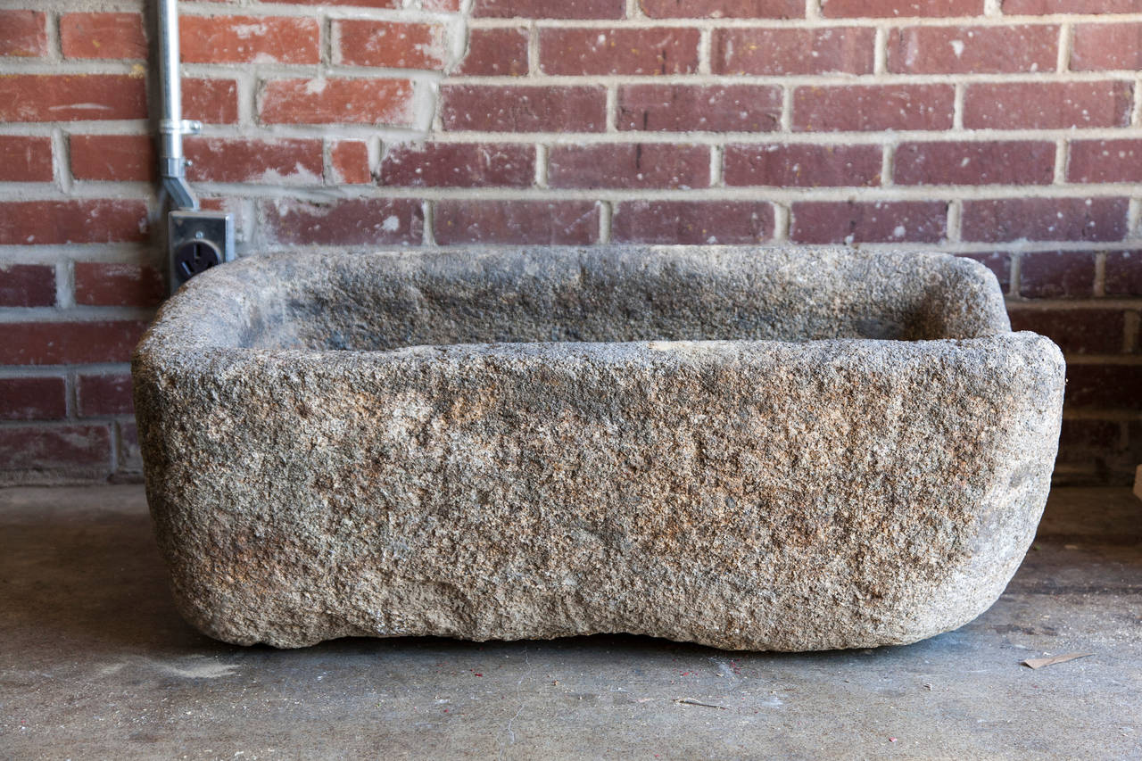 This beautifully weathered 19th century hand-carved limestone trough was originally used on a farm to feed animals. An extremely heavy and sturdy piece of stone, this vessel would be ideal as a fountain basin or lavabo in a garden or as a planter.