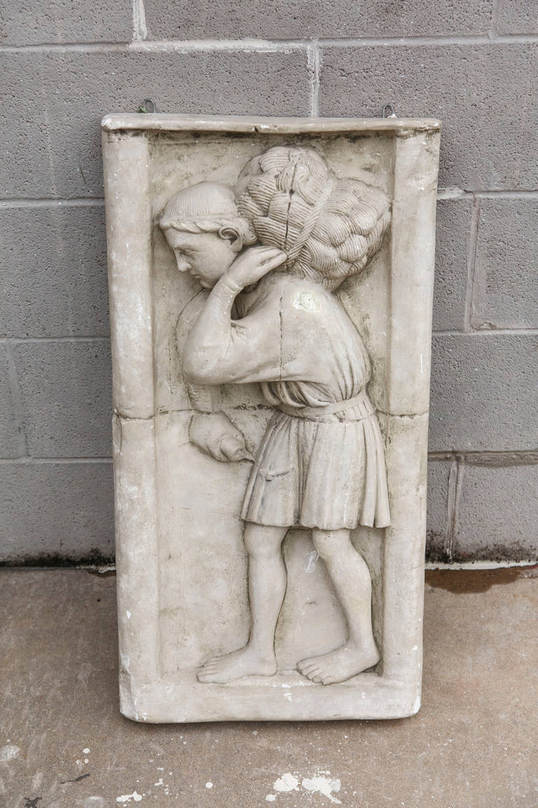 This large three dimensional plaster of Paris wall piece depicting a medieval figure carrying his bundle was produced in the Louvre Musuem studios as an original molding of a piece of art in its collection.  Its stamp on the back reads 