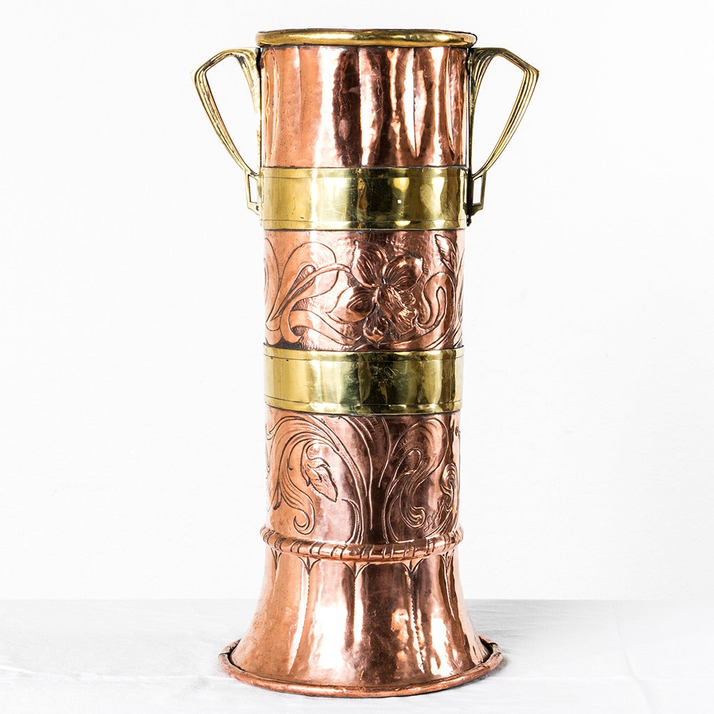 This stunning and unusual example of Art Nouveau design is handmade of copper and brass with repoussé floral details.  Created around 1900 at the height of the Art Nouveau movement in France, this elegant Belle Époque umbrella stand captures the