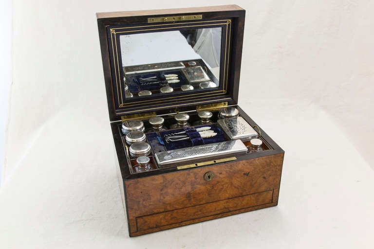 English burled walnut traveling box with bronze plaque on lid engraved with the name of the noblewoman, Mme de Latour, who originally owned it. Interior holds complete set of crystal toiletry bottles with silver lids and dressing tools with