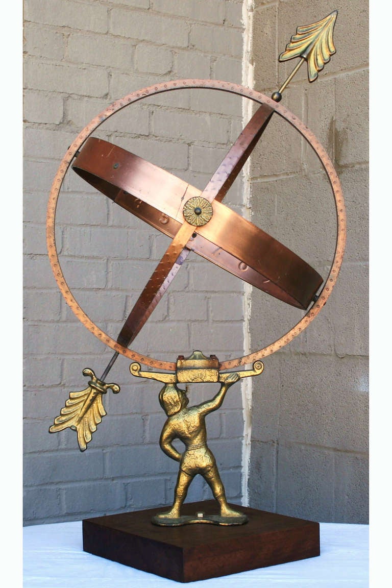 This twentieth century armillary sphere, with Atlas holding the earth, is made of copper, brass, and bronze on a deep walnut base. The hours of the day on the underneath side of the copper center band indicate its original use as a sundial.