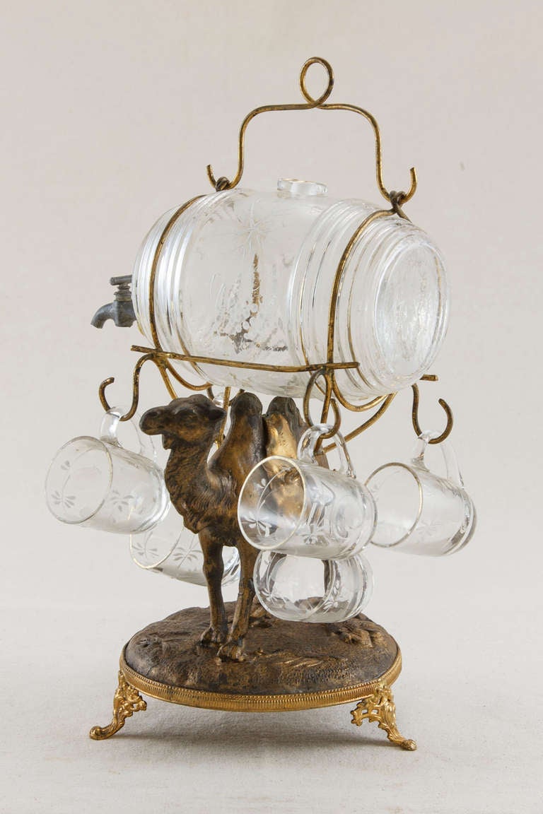 This rare Napoleon III gilt bronze cave à liqueurs or liquor caddy will make a stunning serving piece or can be enjoyed as a purely decorative object.  The dromedary is carrying a hand painted crystal barrel and six hand painted glasses.