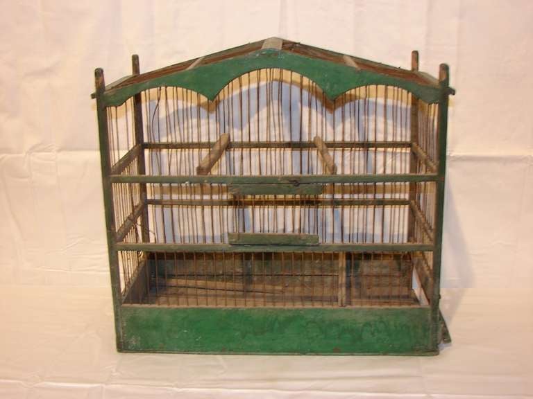 This green painted wood and wire birdcage with pitched roof and arched gables would make a wonderful country house decor addition.