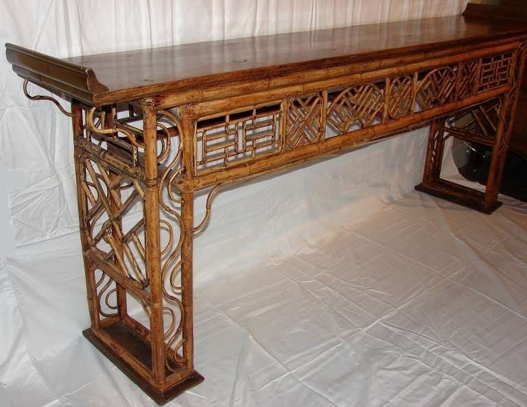Spectacular console table of bamboo with fretwork insets. Yew wood top with upwardly curved flange ends and simple, flat, rectangular yew wood  feet.  Please note that the height is 35.5 inches when measured to the tops of the flange ends.  The