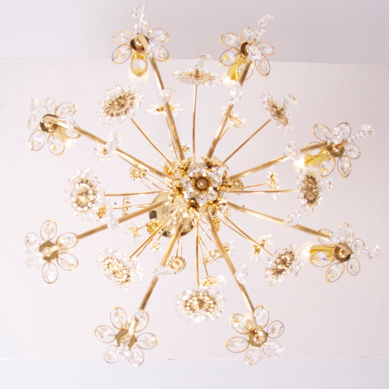 Très glamour et grand lustre à fleurs avec des centaines de cristaux de différentes tailles. Superbe lustre en laiton plaqué or avec 8 ampoules éclairant les merveilleuses fleurs en or et en verre. Le lustre est étiqueté avec Palwa.
Pour plus de