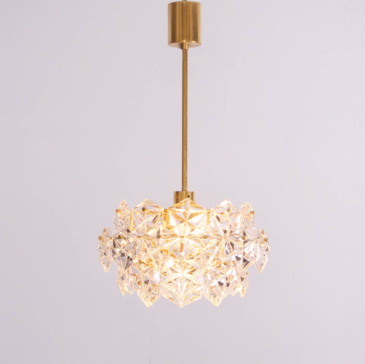 Stunning four-tier chandelier by Kinkeldey with huge gem-like crystals and gold-plated brass frame.

Same lamp in other sizes are also listed.

Takes four bulbs.
To be on the the safe side, the lamp should be checked locally by a specialist