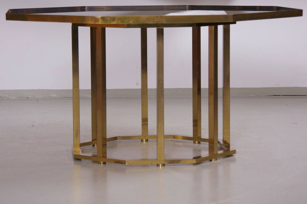 Beeindruckender, sehr großer und massiver Couchtisch von Maison Jansen. Die Tischplatte aus geräuchertem Glas ist von einem Messingrahmen umgeben.

