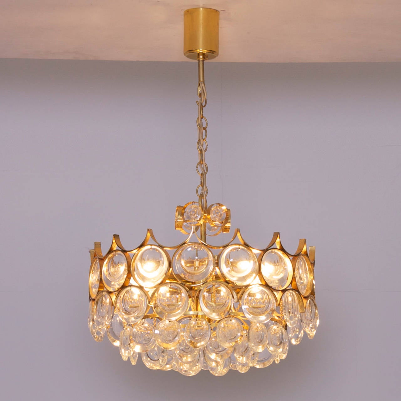 Stunning, high end quality chandelier from Palwa. The chandelier has a 24-carat gilt brass frame with wonderful jewel like glasses, which floats every room in a beautiful warm light. It is fitted with four E14 bulbs.


