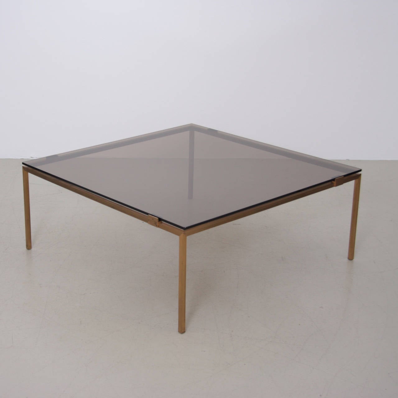 Solid brass base and smoked glass top. Very architectural piece with elegant proportions. High quality!.

 