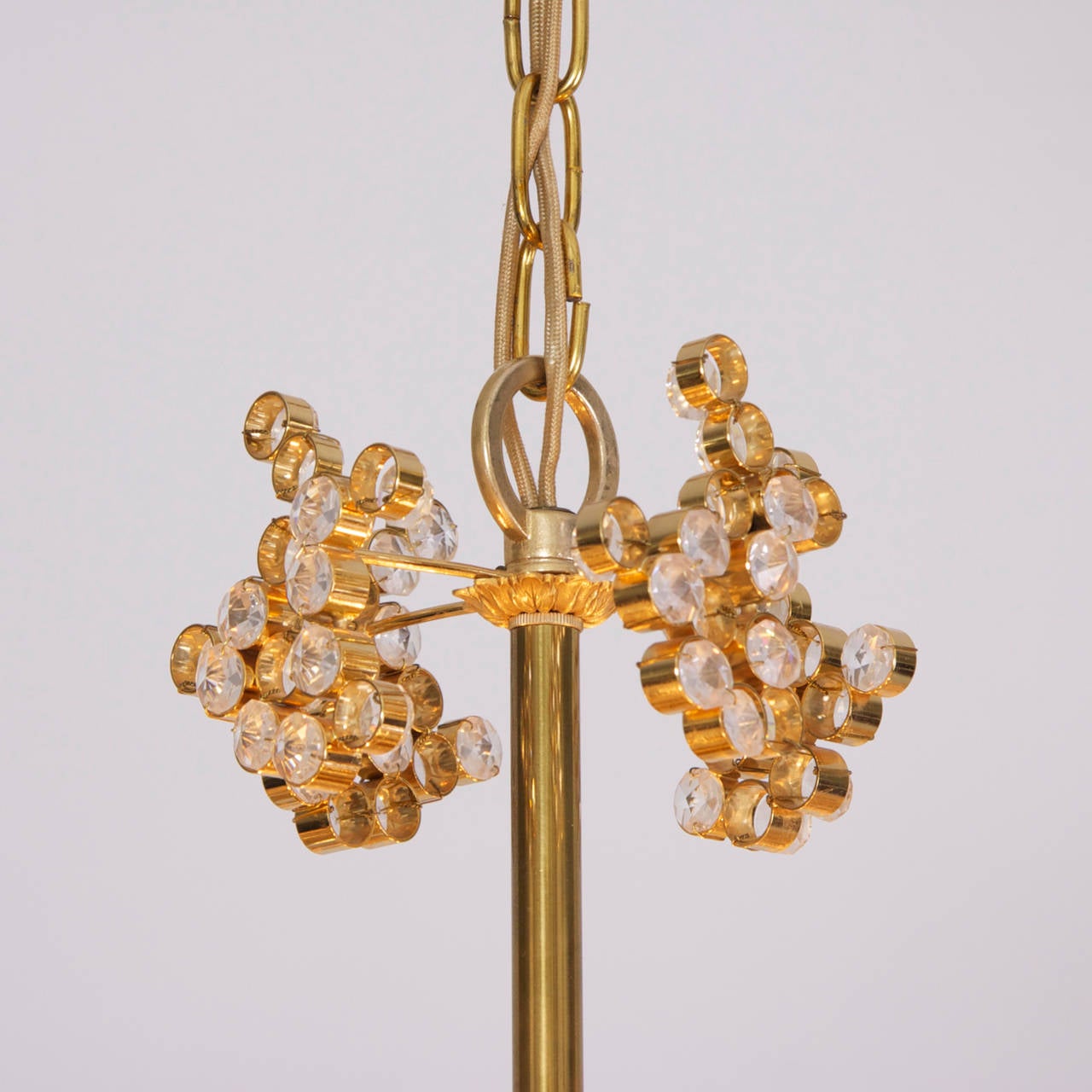 One of two outstanding Palwa chandeliers from the 1960s. The 24-carat gold-plated brass frames are encrusted with hundreds of high quality diamond like crystals. The chandeliers are handmade and in excellent condition and float every room in a