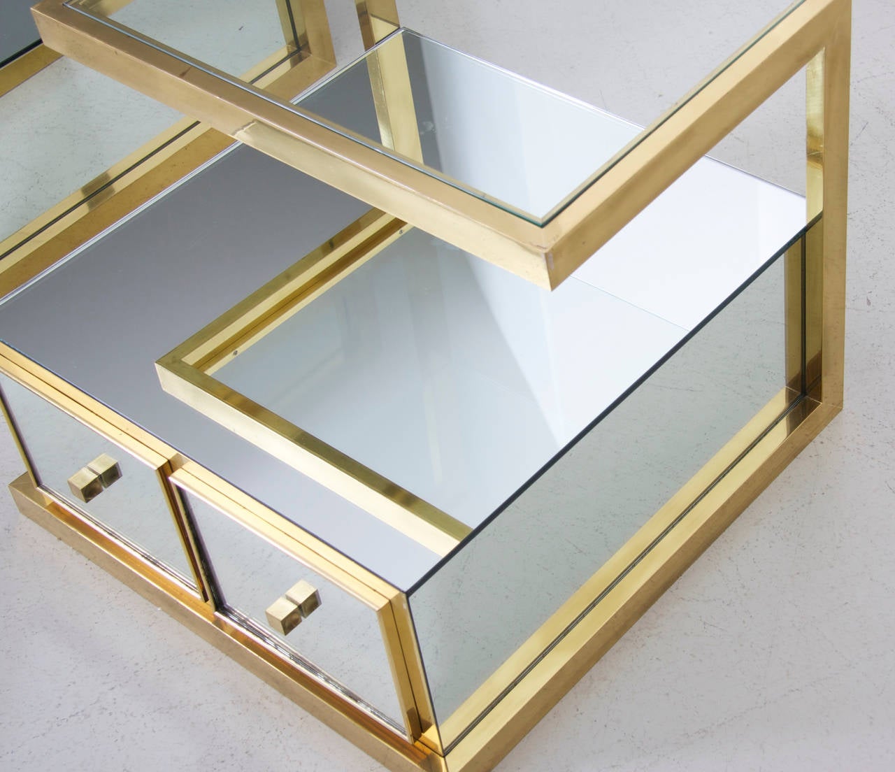 Very elegant, massive brass and mirror pair of bedside tables. Furniture of the French designer Michel Pigneres are very rare to find and really jewels. This pair of tables is in very good condition and brings the Hollywood Regency glamour in each