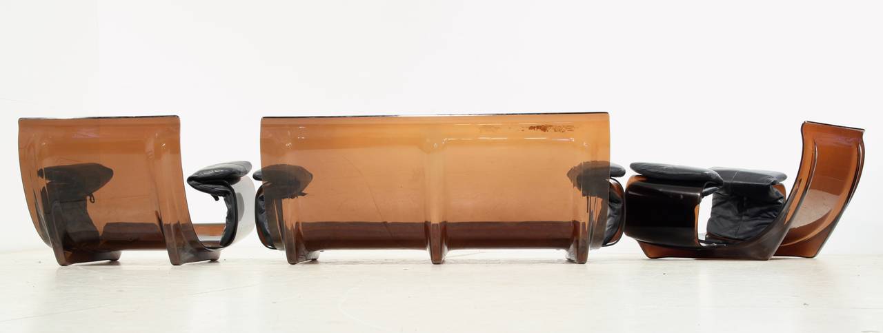 Une suite modulaire conçue par Michel Ducaroy pour Ligne Roset, France. L'ensemble, composé d'un canapé et de deux chaises longues, est constitué d'un cadre en plexiglas brun et d'un revêtement en cuir noir.

Les mesures indiquées sont celles du