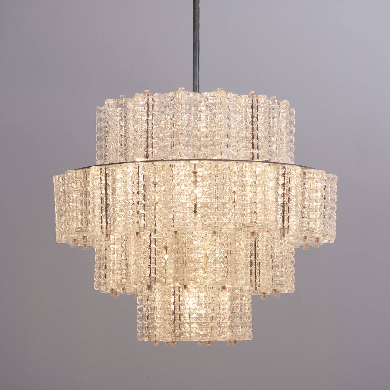 Wonderful and rare glass chandeliers by Austrian high end manufacturer Austrolux. The chandeliers are a high quality production from the 1960s. The light shines through the structured glasses and creates a cozy atmosphere in every room. The