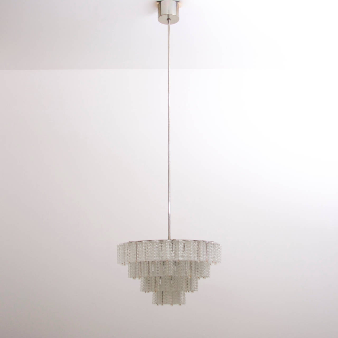 Wonderful and rare glass chandeliers by Austrian high end manufacturer Austrolux. The chandeliers are high quality production from the 1960s. The light shines through the structured glasses and brings a cozy atmosphere in every room. The chandeliers