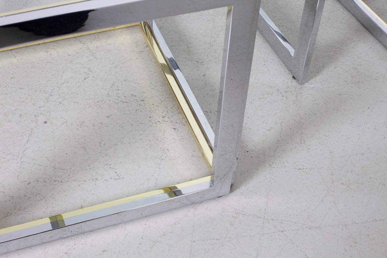 Beautiful  coffee table with 4 nesting tables in brass and chrome by Maison Charles. The glass plates are loosely inserted to create the table surfaces. The table is in very good condition.