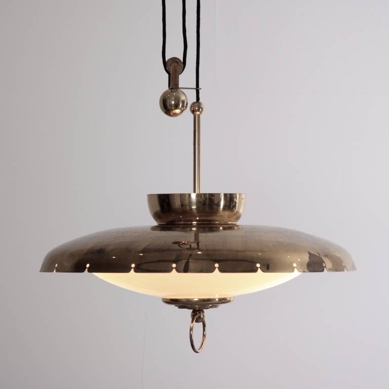 Beautiful brass Italian chandelier manufactered in the Fifties.
Brass mounts and counterweight with brass shade and pierced diffuser.White opaline glass diffuser.
The height of this chandelier can be adjusted using the counter-weighted 'pulley-like