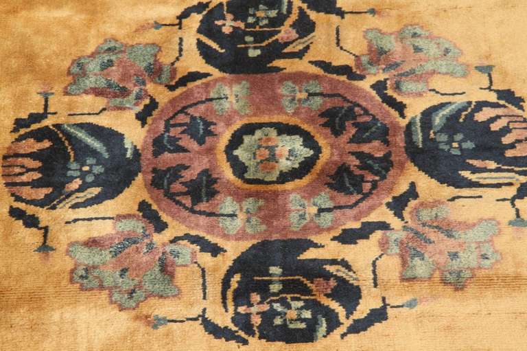 Beautiful wool carpet hand-knotted in China mainly during the 1920s and 1930s. Colors are bright and bold. Designs are simple but very decorative: a thick border with floral arrangement stretched toward the centre of the rug.
