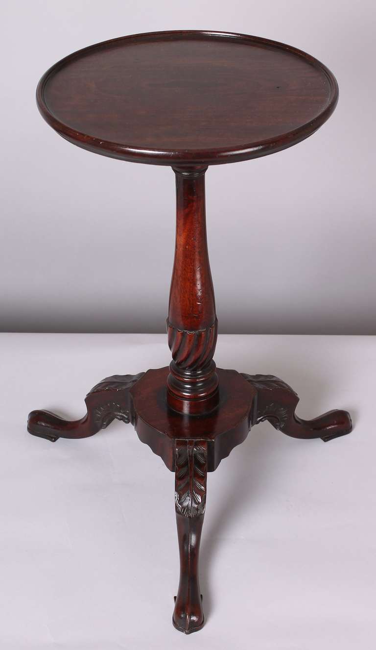 Rare George III period mahogany kettle-stand; the circular dished top mounted on a baluster shaft with a spiralled knop and a platform base with cabriole legs, carved with acanthus leaves and scrolled flamework motifs. Circa 1760