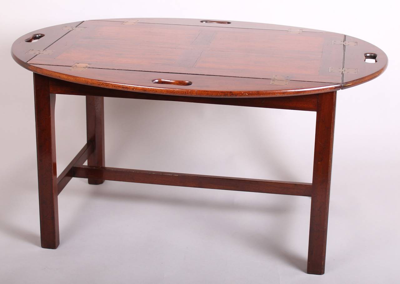 Early 19th century mahogany butler's tray with a panelled base and drop sides; mounted on a specially made modern stand for use as a coffee-table. Tray circa 1820.