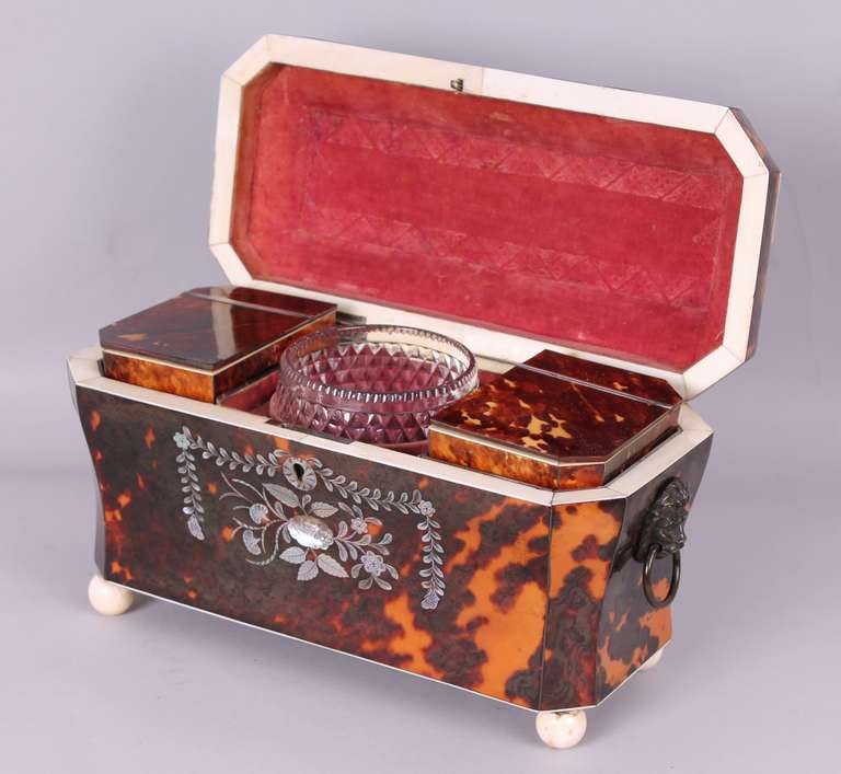 Fine Regency tortoise-shell tea-caddy of waisted shape with angled corners and a domed lid, richly inlaid with mother-of-pearl flowers, foliage, paterae and swags of leaves, edged with ivory stringing; the interior with its original rose velvet