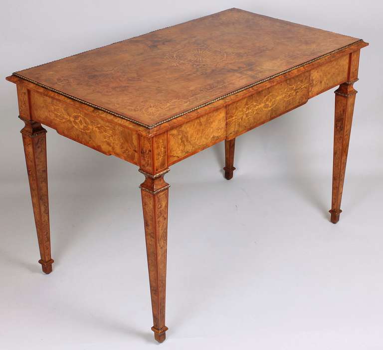 High quality mid nineteenth century burr walnut centre-table in the French manner; the finely-figured quarter-veneered top with tulipwood bandings and elaborate inlaid boxwood decoration; the shaped frieze fitted with a 'concealed' mahogany-lined