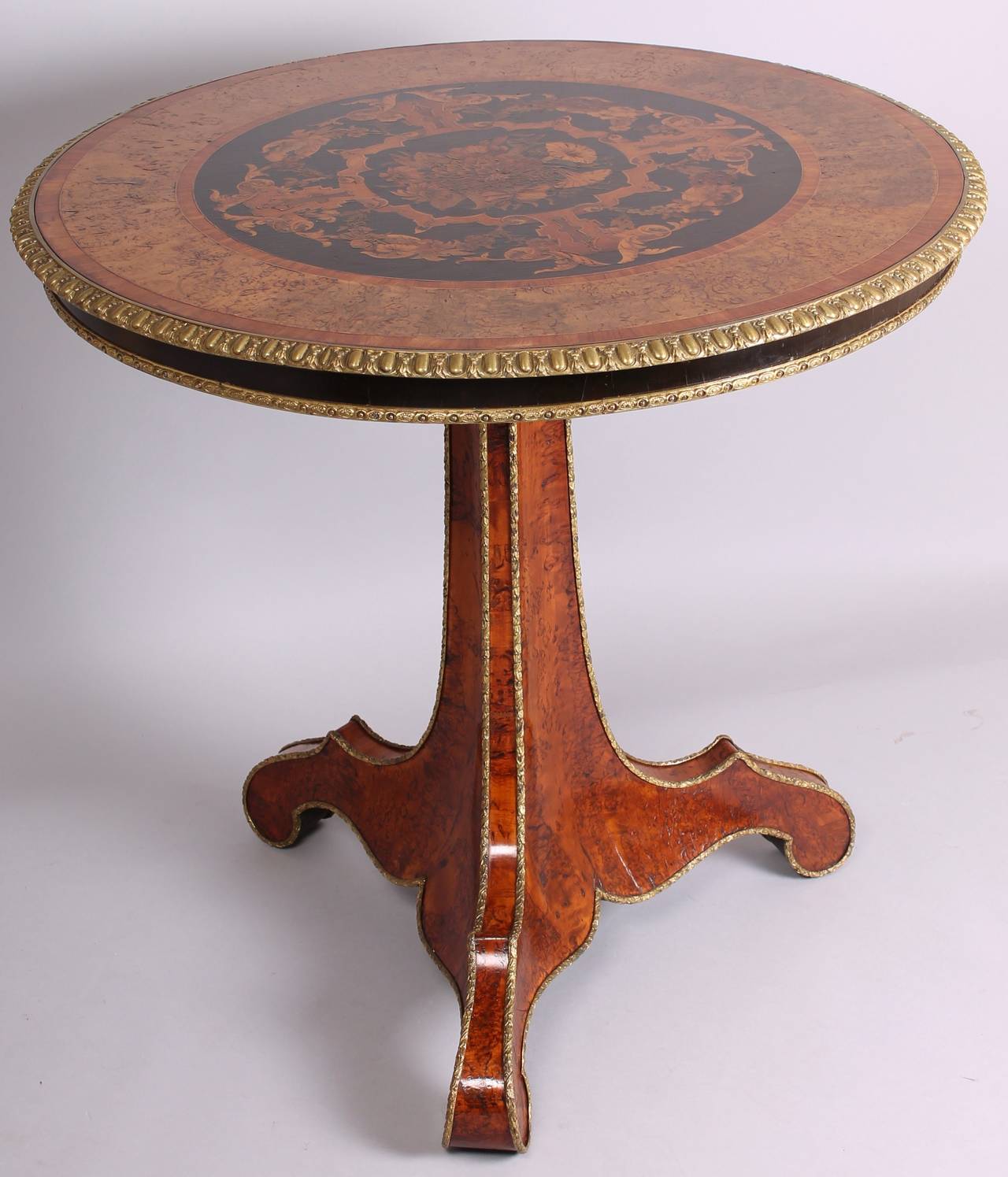 Exceptionally fine mid nineteenth century burr wood and marquetry centre-table of the character and quality of furniture supplied by Edward Holmes Baldock (1777-1845); the circular top with a finely cast and chased ormolu edge, surrounding a broad