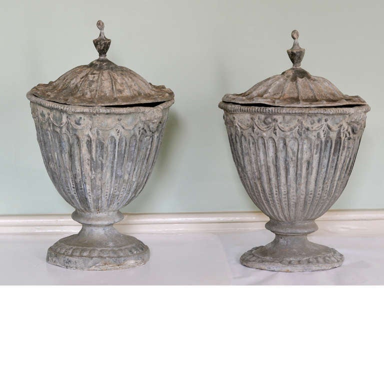 A pair of nineteenth century Neo-Classical lead urns, in the style of Robert Adam, the fluted body with gadrooned rim above swags flanked by female masks, on waisted and turned socle.

Available to view at LASSCO Brunswick House.