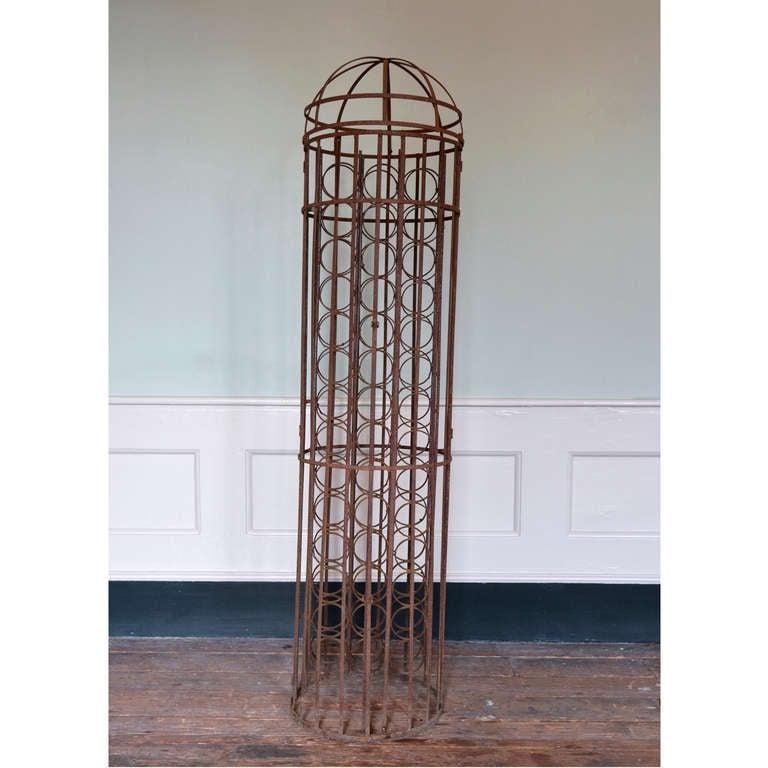 Cage à vin cylindrique en fer forgé, avec sommet bombé et capacité de quarante-deux bouteilles.

Disponible à Brunswick House, Londres