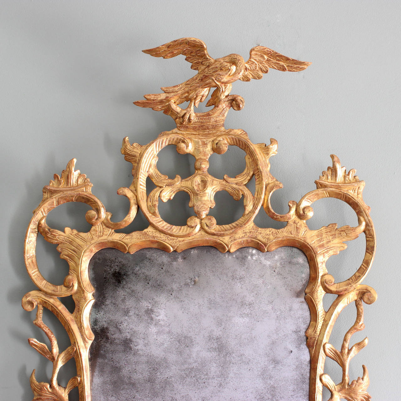 A George III giltwood mirror, circa 1760, the original plate surrounded by frame carved with C-scrolls and foliage, surmounted by Ho-Ho bird cresting. 

Available to view at Brunswick House, London.

Height 121 cm, width 63 cm.