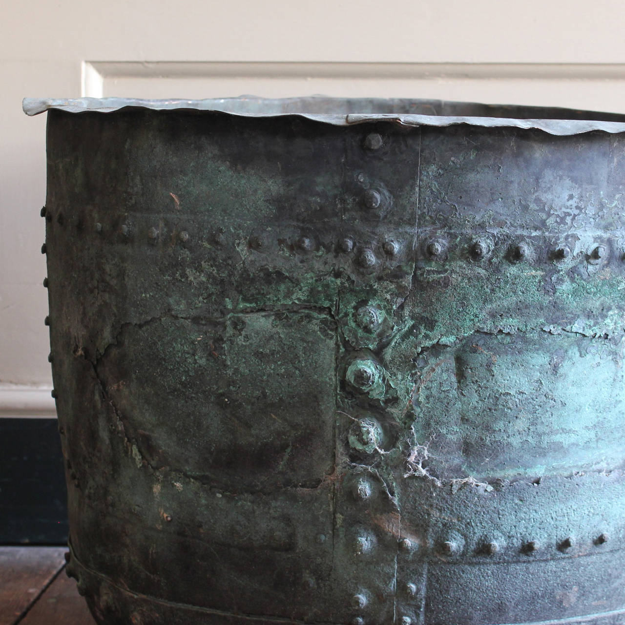 A nineteenth century riveted copper vat, with old patched repairs and well patinated verdigris exterior.

Available to view at Brunswick House, London.

Height 54cm, diameter 70cm.