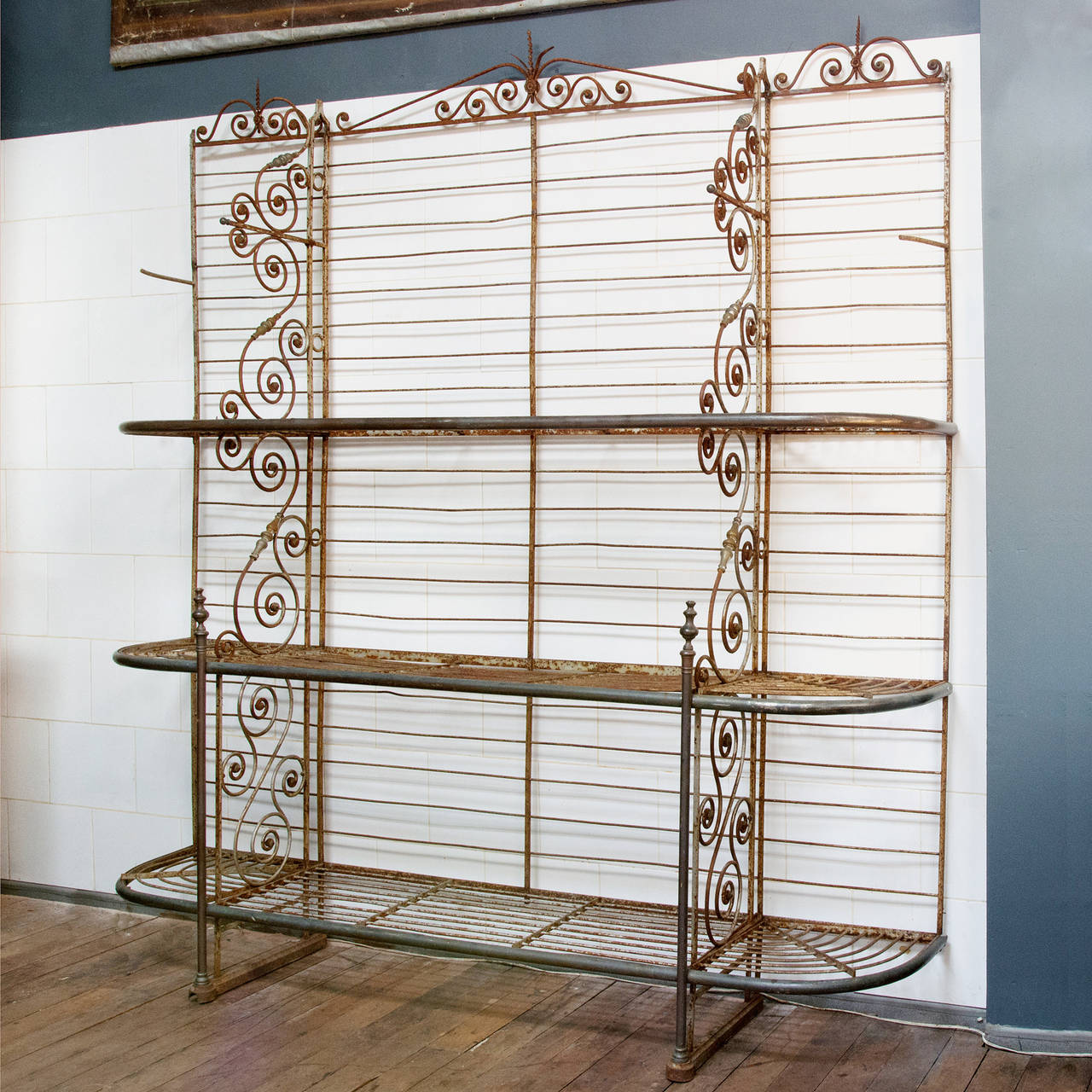 A French wrought iron Présentoir de Boulangerie, 19th century, the three tiers supported by s-scrolls, stamped to the base 'Plaire Beauvilain 99 Rue des Orteaux Paris'.

Available to view at Brunswick House, London.

243cm high, 221cm wide,