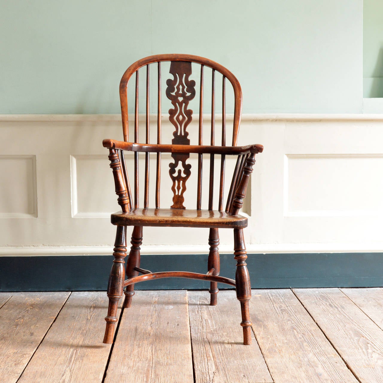A Yew and Elm high splat back WIndsor armchair, Nottinghamshire circa 1850, with elaborate fret-cut splat, turned arm supports with notched arm bow, on double ring turned legs with crinoline stretcher.

Available to view at Brunswick House,