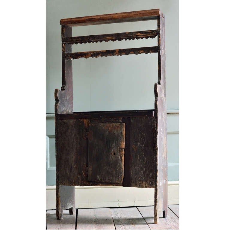 A primitive dresser of diminutive proportions, Spanish, probably eighteenth century, the super structure with shaped friezes, on base of simple boarded and joined construction. With repairs, original wrought ironwork.<br />
<br />
