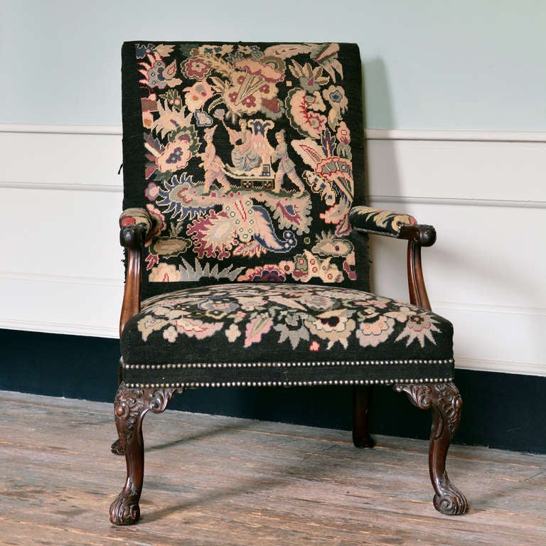 A George II style walnut Gainsborough chair with gros and peiti point needlework upholstered back and seat, the downswept arms with foliate carving, the cabriole legs carved with cabochon and acanthus.

Available to view at Brunswick House, London.