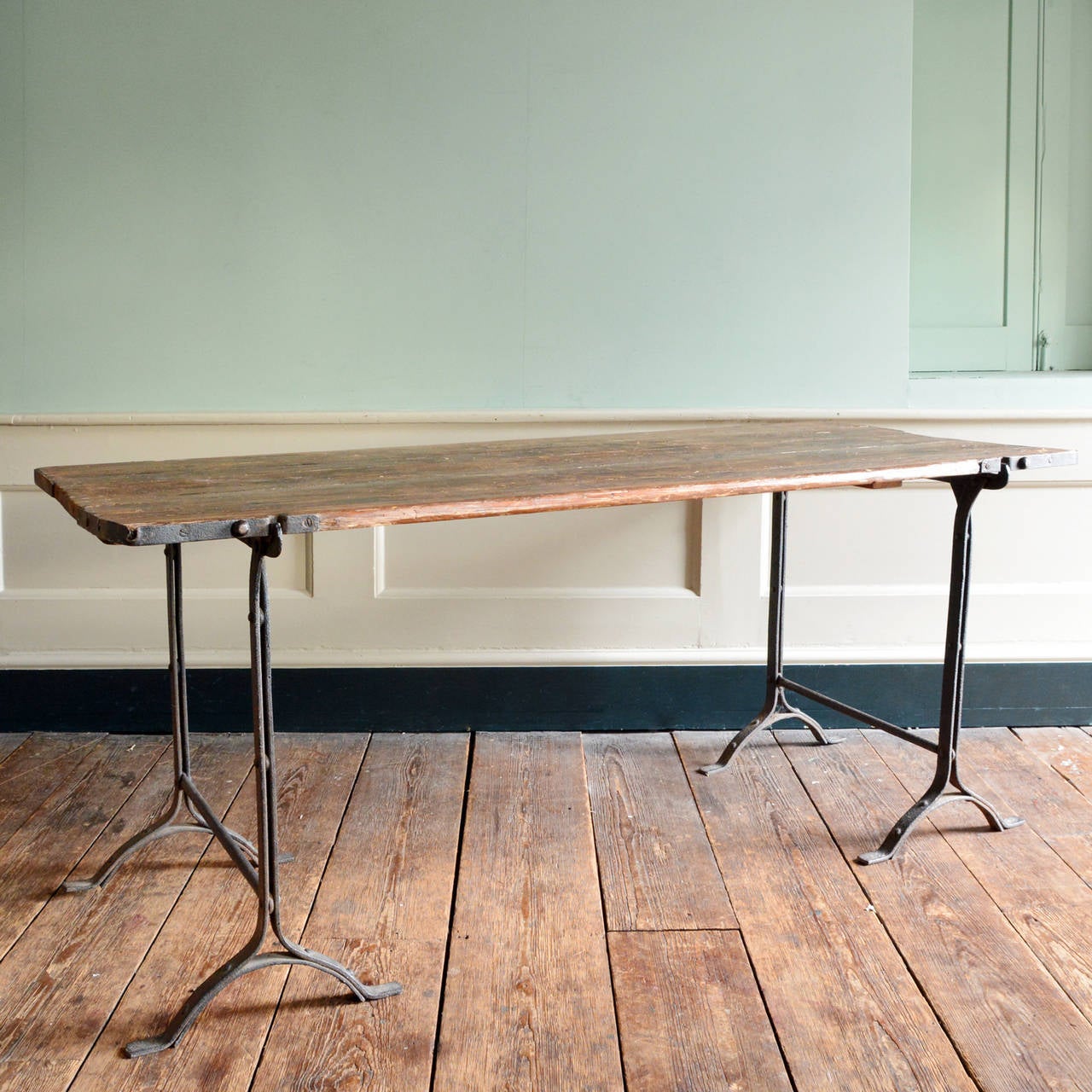 An English Arts & Crafts trestle table, the bound pine top on wrought iron supports.

Available to view at Brunswick House, London.

Length 182cm, width 77.5cm, height 76cm