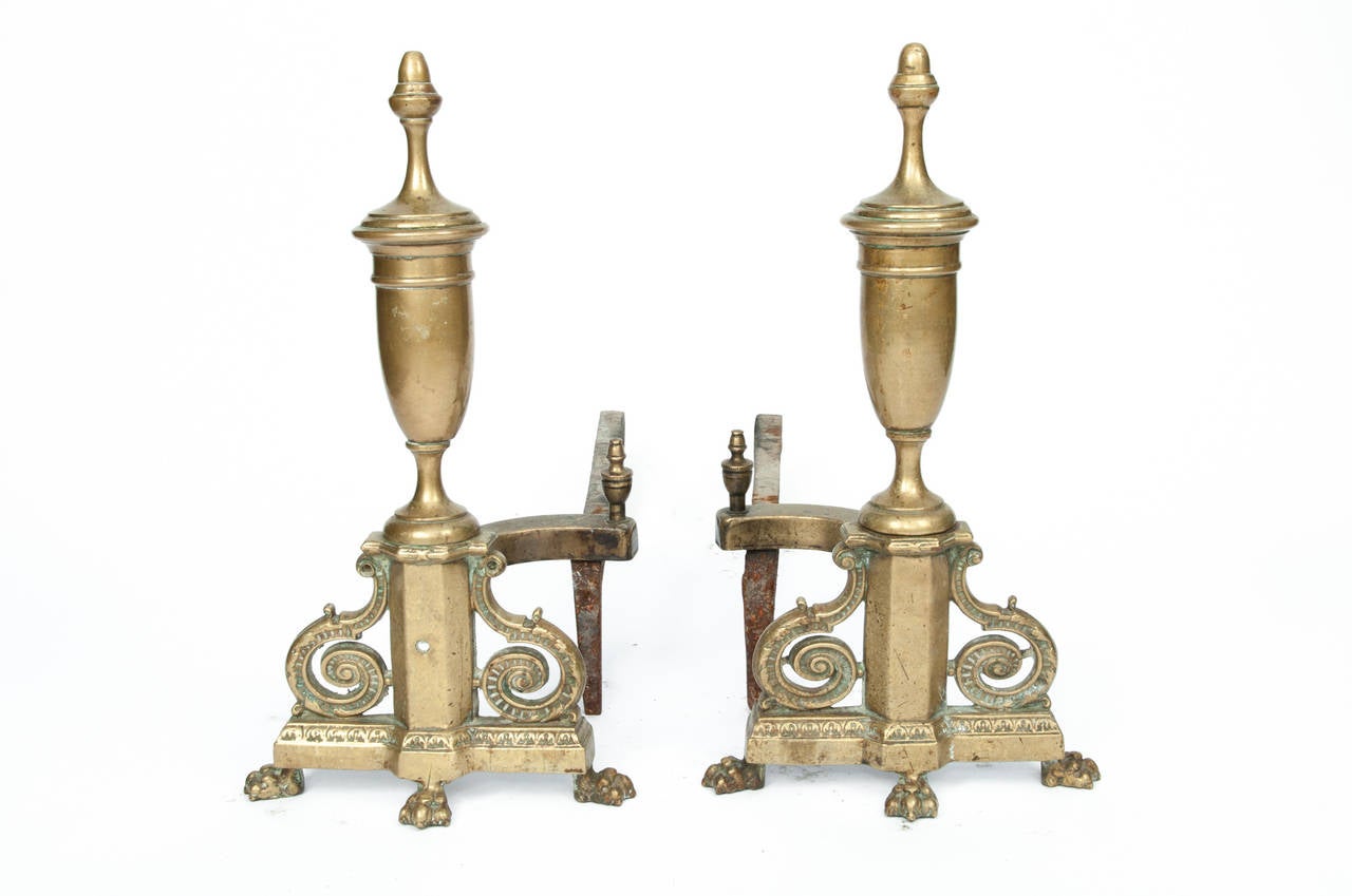 An antique pair of brass andirons.