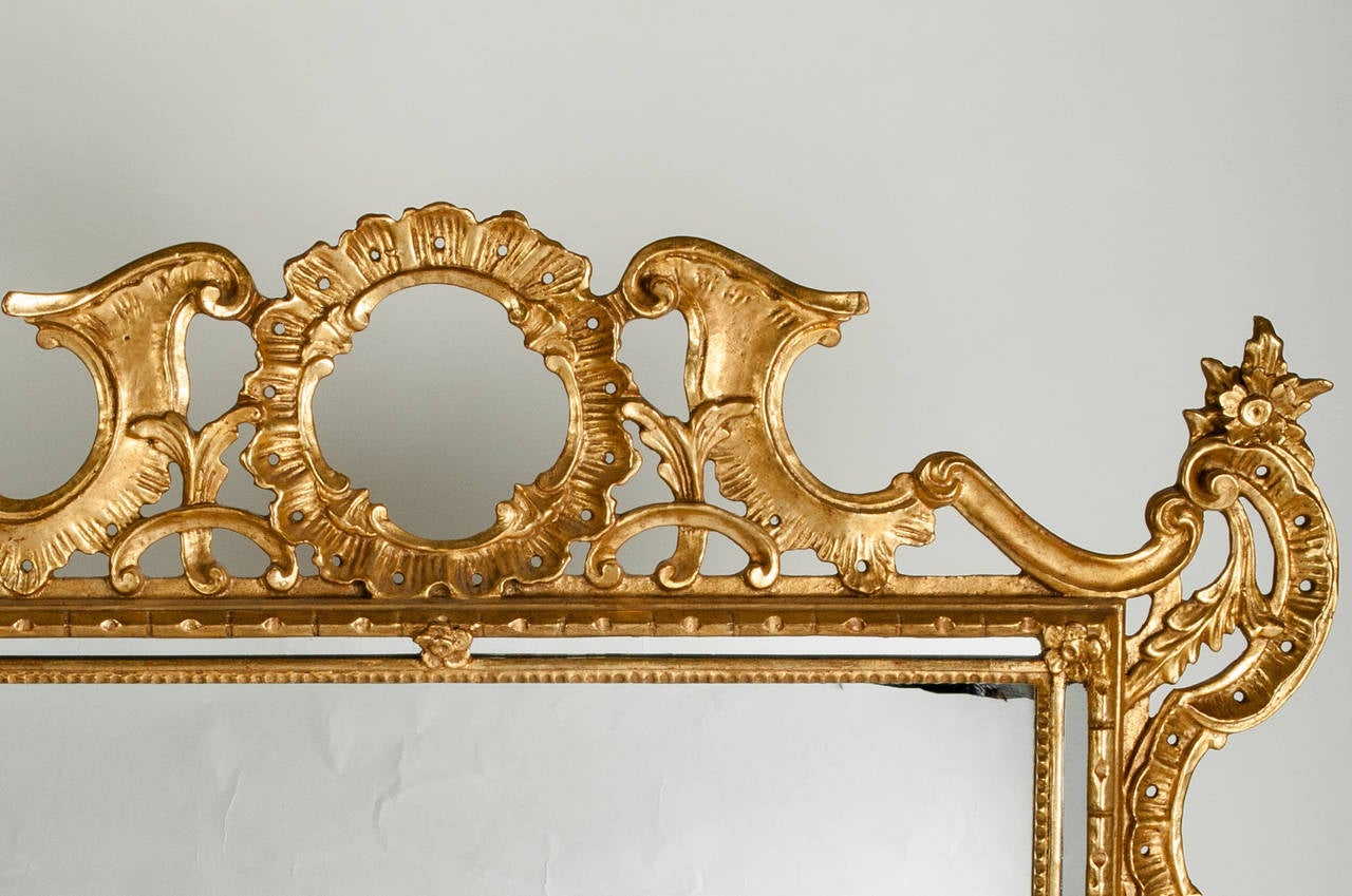 A vintage ornately carved wood frame and gold gilt hanging wall mirror. This piece is just exquisite and can be use anywhere in any space. This hanging mirror is in excellent vintage condition. It measures 34 inches high x 32 inches width. The depth