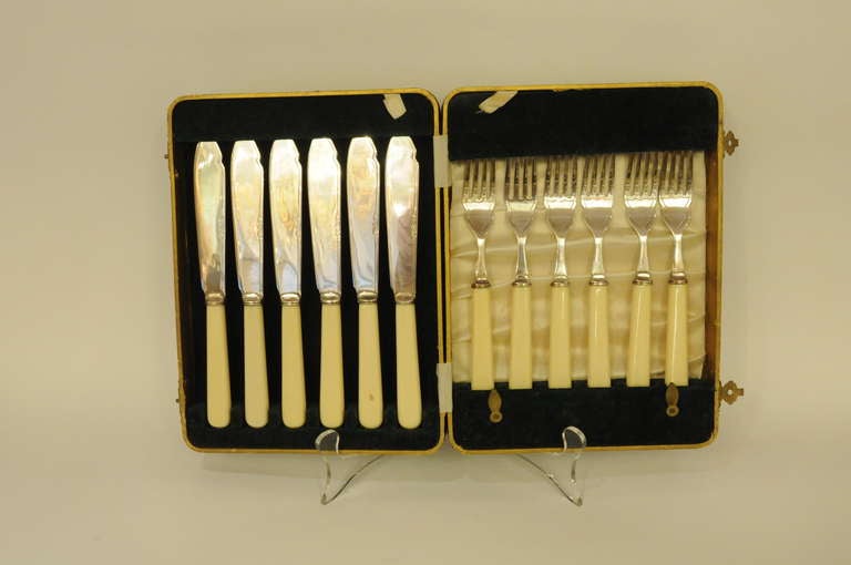 Flatware set. Six knives and six forks with bone colored enamel handles. Marked 