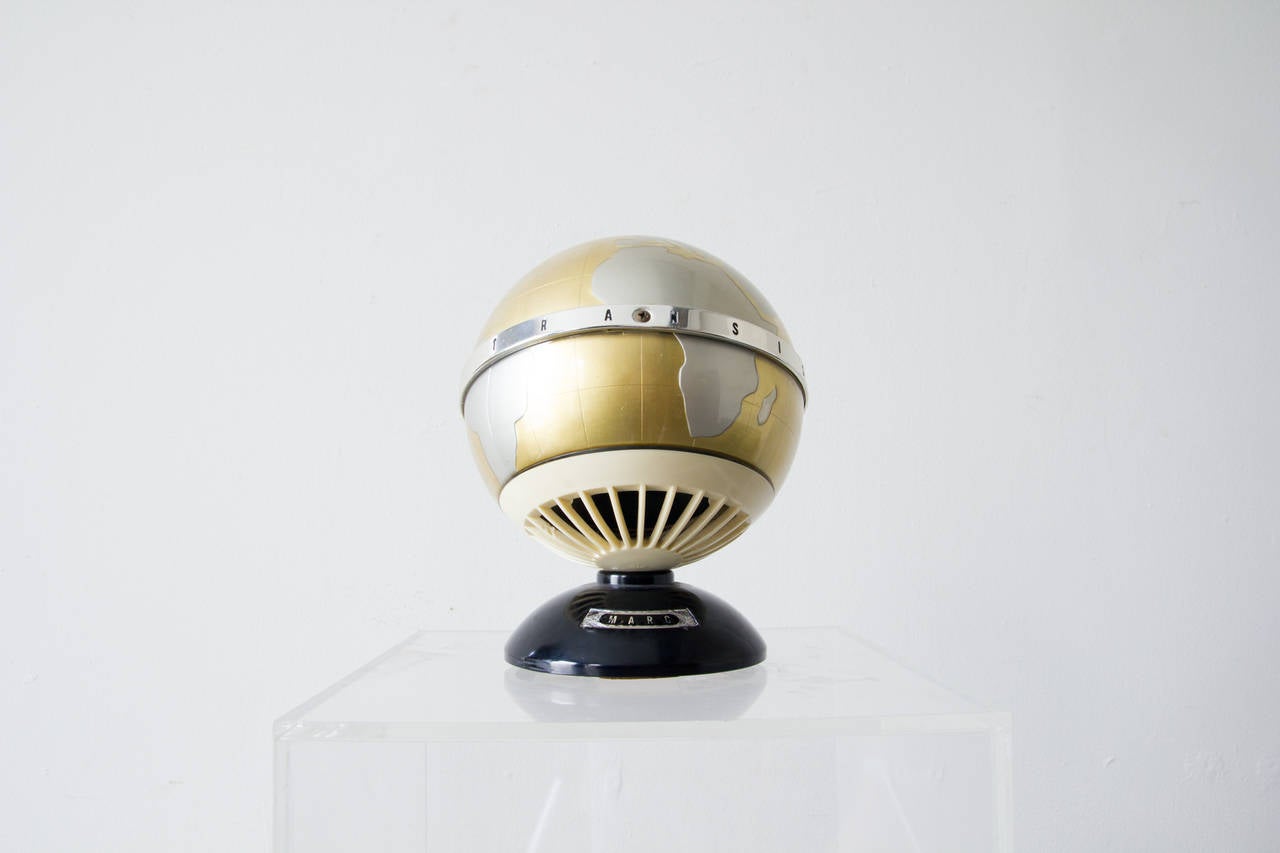 This globe themed transistor radio features silver and gold topography. At the North Pole, a rotating switch turns the unit on and adjusts volume levers. Its frequency range is limited to medium waves, from 540 – 1600 KHz. There is an 1/8th inch