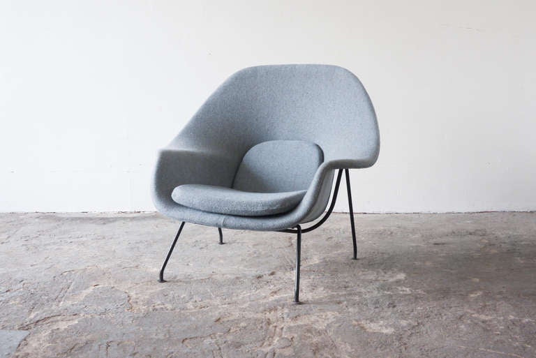 This Womb Chair, by Eero Saarinen for Knoll International is a specimen of an early production run, as recognizable by the iron frame and legs. It has been reupholstered in a period appropriate powder blue/gray twill.