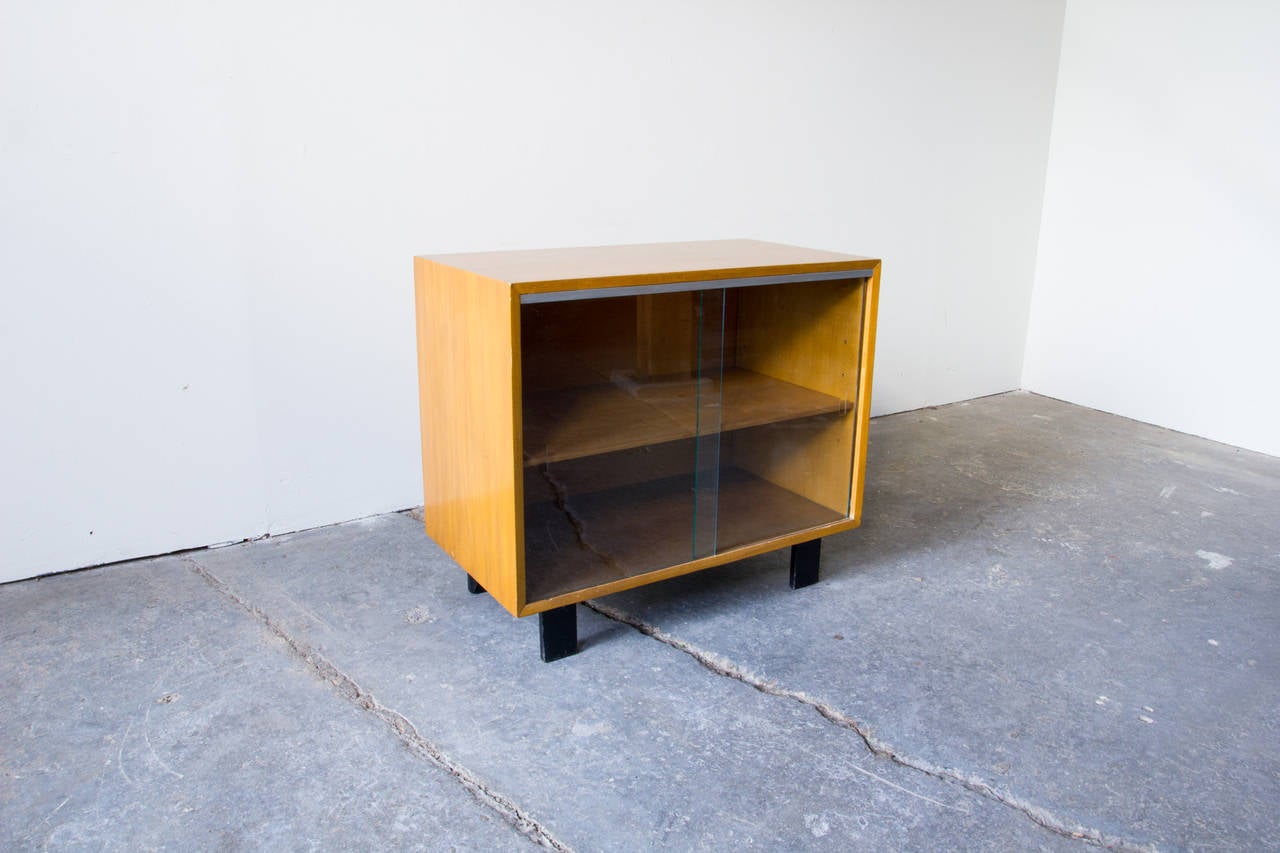 A medium sized cabinet with glass doors by George Nelson for Herman Miller. As is expected of Nelson's Basic Cabinet Series, this case piece is functional  and straightforward. Birch veneer covers the plywood frame of the cabinet, which stands on