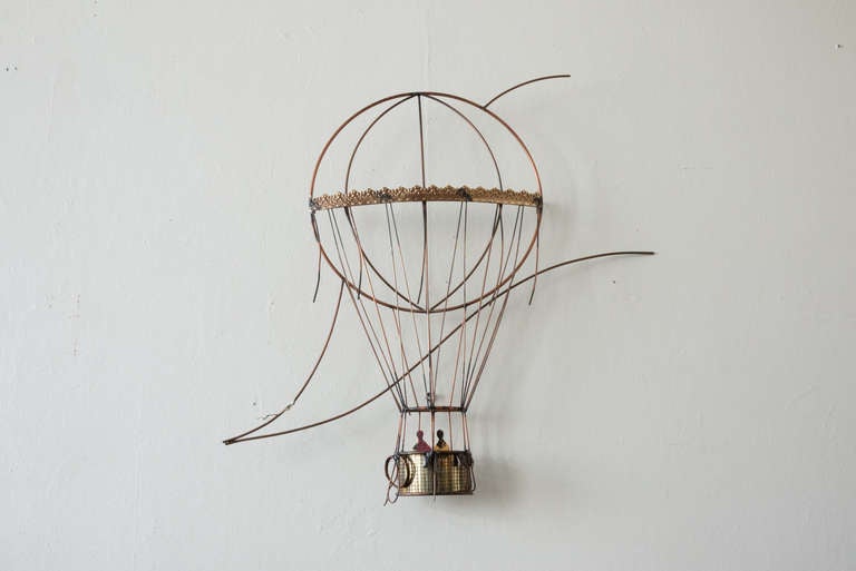 This hot air balloon wall sculpture by C. Jere is made of welded brass components. it depicts two people operating a hot air balloon, in great detail. It is signed and dated.