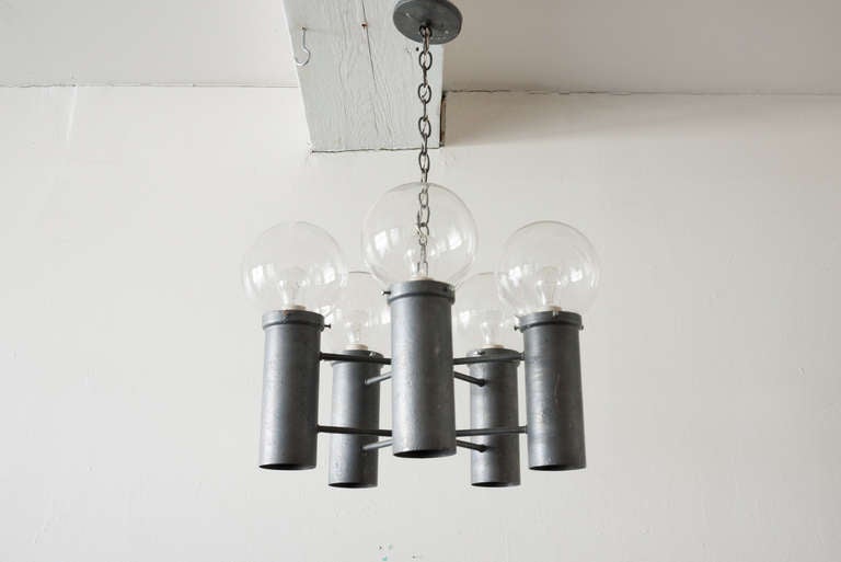 This chandelier by Lightolier lights from the top and bottom. The light operates on a three-way switch, allowing for each or both to be used. On top, the bulbs are surrounded by thin glass globes, original to the piece.