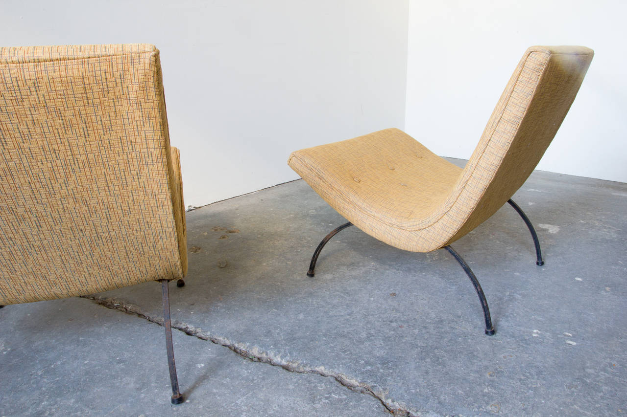 The iconic scoop chair by Milo Baughman in new buttoned upholstery with bent iron legs. The design and pitch of these chairs cradle the sitter, and allow for a variety of sitting positions.
