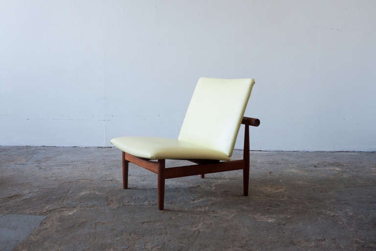This Model 137 chair by Finn Juhl was sold by John Stuart Inc., and is labeled as such. Commonly known as the Japan chair, the chair's design is inspired by the famous Itsukushima watergate in Japan. This chair features its original citrine vinyl,